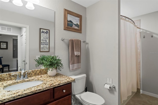 bathroom with vanity, toilet, and tile flooring