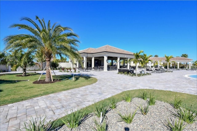 view of property's community featuring a patio area, a gazebo, and a lawn