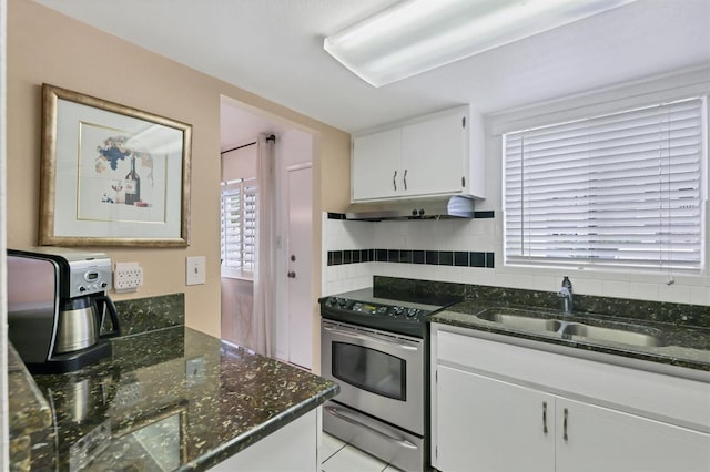 kitchen featuring white cabinets, light tile floors, sink, stainless steel electric range oven, and dark stone counters