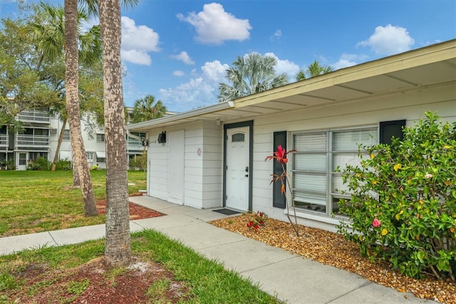 view of exterior entry with a yard