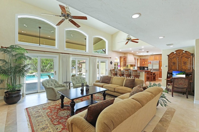 living area with recessed lighting, ceiling fan, and a towering ceiling