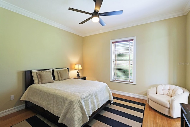 bedroom with ceiling fan, baseboards, wood finished floors, and ornamental molding