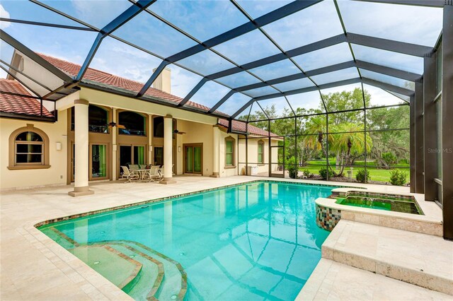 view of swimming pool with a pool with connected hot tub, a patio area, and a ceiling fan