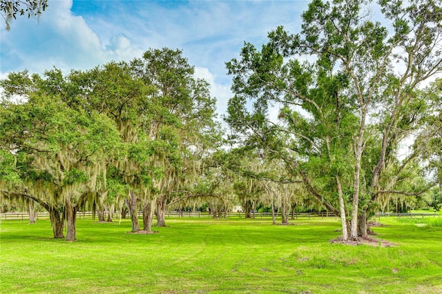 view of property's community with fence and a yard