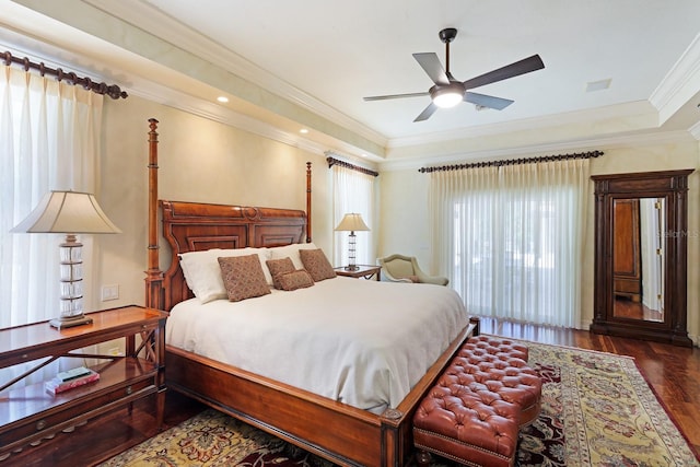 bedroom featuring wood finished floors, visible vents, a ceiling fan, a raised ceiling, and crown molding