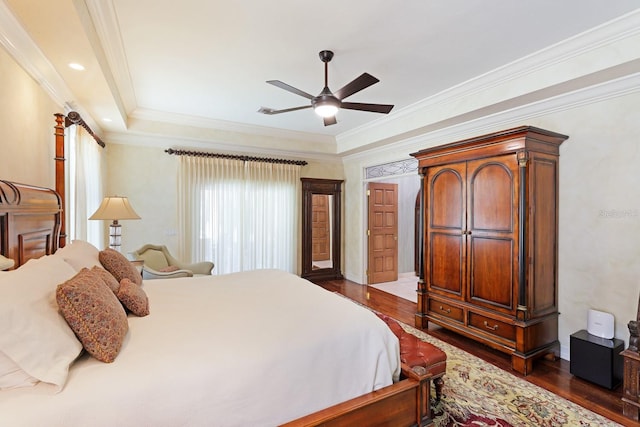 bedroom with dark wood-style floors, ornamental molding, and a ceiling fan