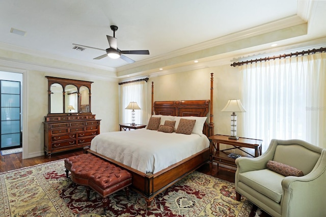 bedroom with ornamental molding, visible vents, multiple windows, and wood finished floors