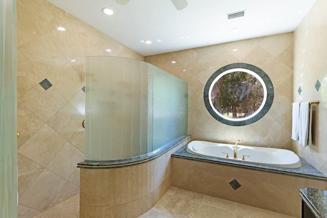 bathroom with visible vents, tile walls, a tile shower, a bath, and tile patterned floors