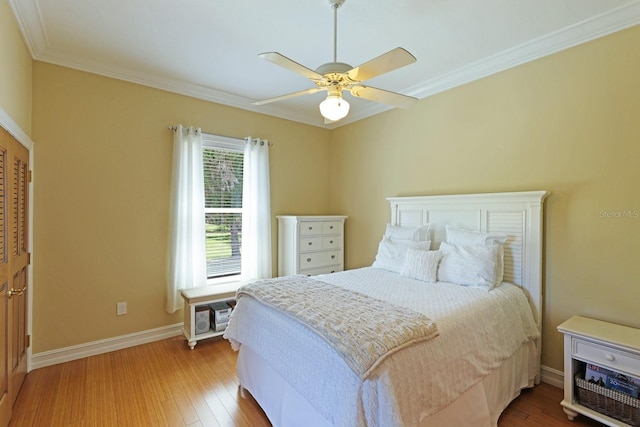 bedroom featuring ornamental molding, a ceiling fan, baseboards, and wood finished floors