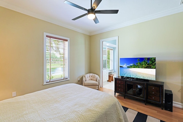 bedroom featuring ceiling fan, crown molding, baseboards, and wood finished floors