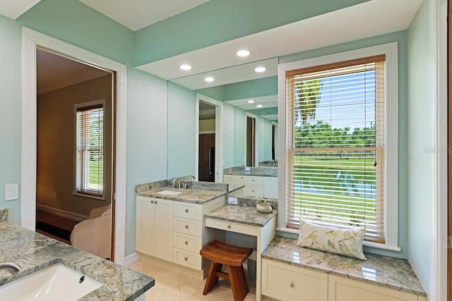 ensuite bathroom featuring plenty of natural light and a sink