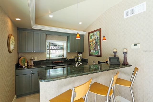 kitchen featuring a peninsula, visible vents, dark stone countertops, a kitchen bar, and pendant lighting