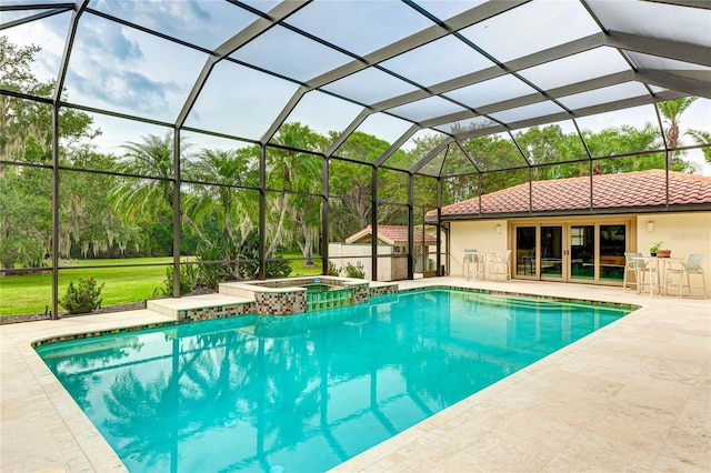 view of pool with a patio area, a pool with connected hot tub, glass enclosure, and a yard