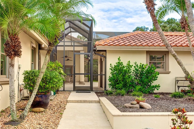 doorway to property featuring a tile roof and stucco siding