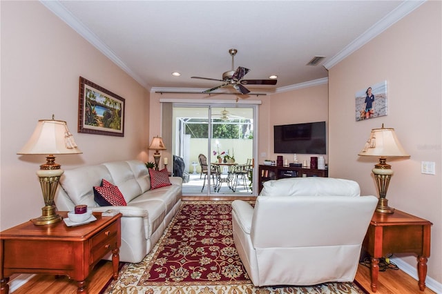 living room with ornamental molding, light hardwood / wood-style floors, and ceiling fan