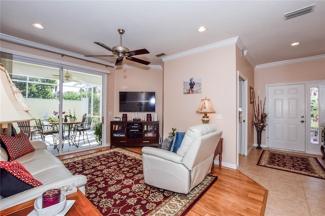 tiled living room featuring ceiling fan and crown molding