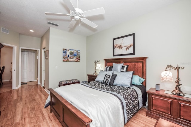 bedroom featuring light hardwood / wood-style flooring, ceiling fan, and a closet