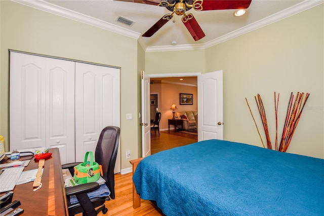 bedroom with ornamental molding, a closet, ceiling fan, and light wood-type flooring