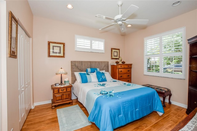 bedroom featuring light hardwood / wood-style flooring, ceiling fan, and a closet