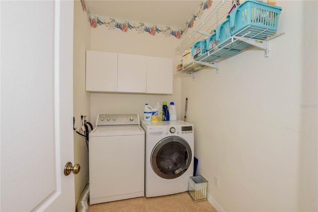 laundry area featuring washer hookup, cabinets, light tile floors, and washer and dryer