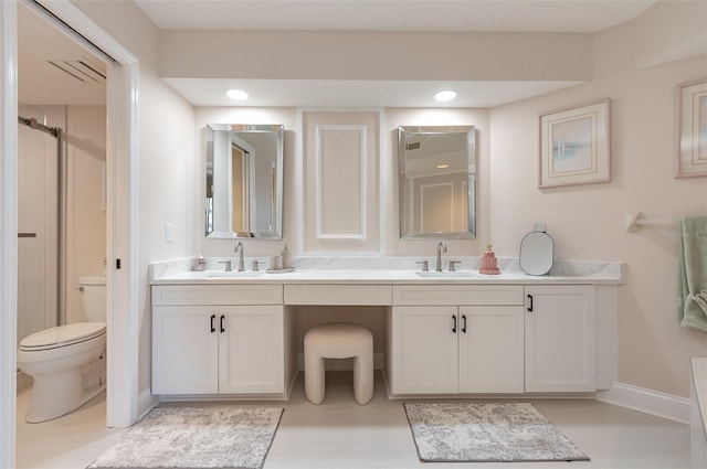 bathroom with vanity, a shower with shower door, and toilet