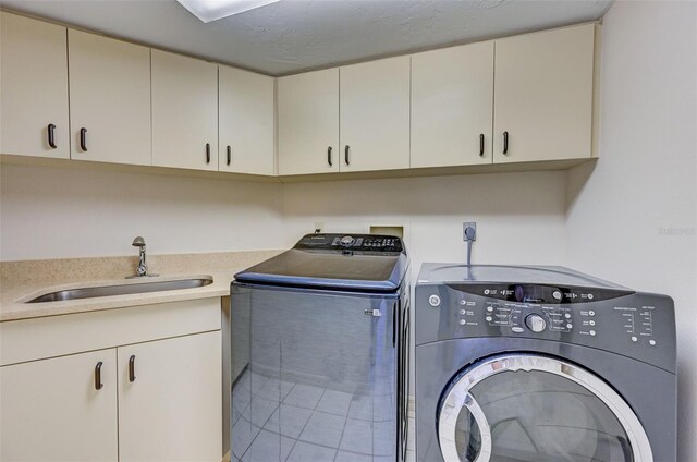 laundry room featuring cabinets, washer and dryer, and sink