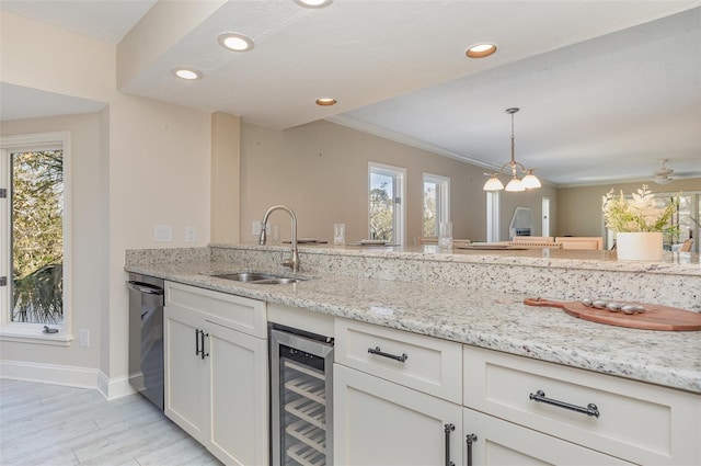 kitchen with wine cooler, white cabinetry, decorative light fixtures, and a wealth of natural light