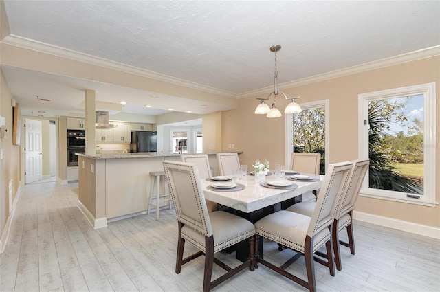 dining room with crown molding, a chandelier, and light wood-type flooring