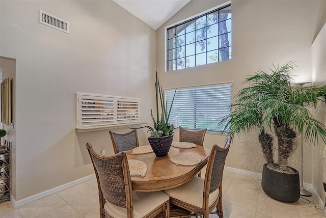 tiled dining room with high vaulted ceiling