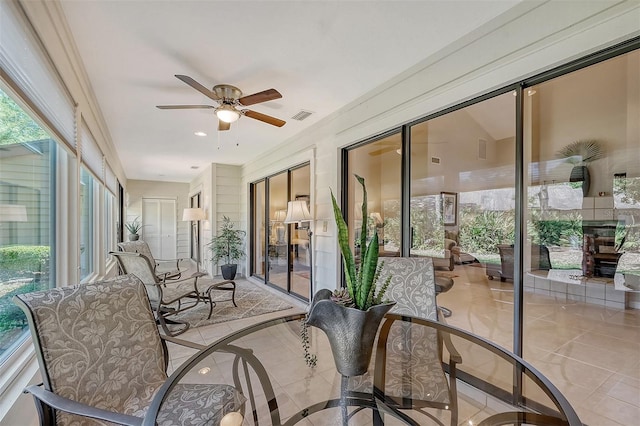 sunroom / solarium featuring ceiling fan