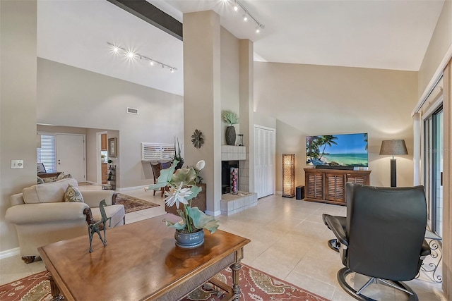 tiled living room with beamed ceiling, high vaulted ceiling, track lighting, and a fireplace