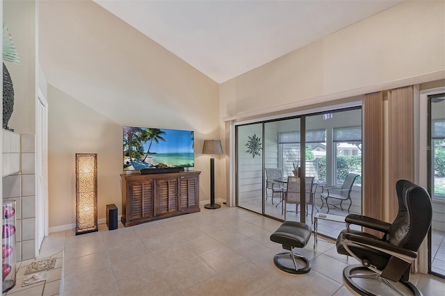 living area with high vaulted ceiling and light tile flooring