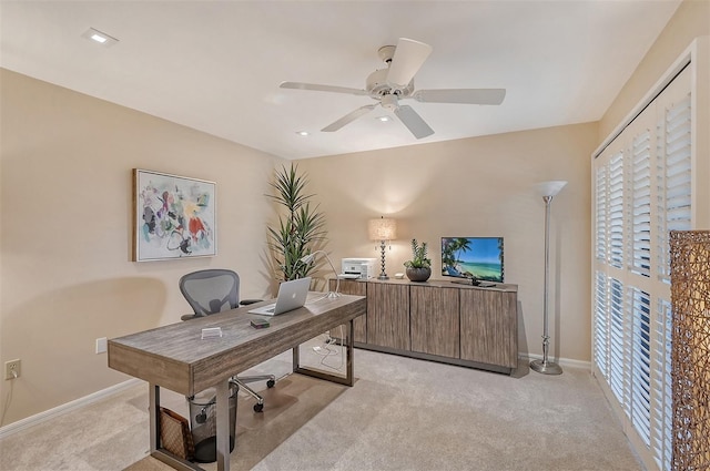 carpeted office space with ceiling fan