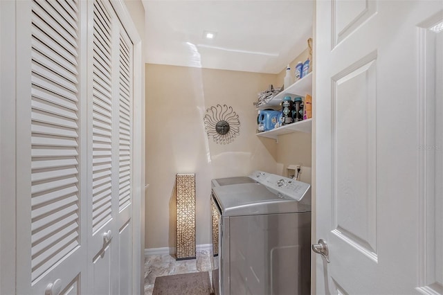 laundry room with washing machine and dryer and light tile floors