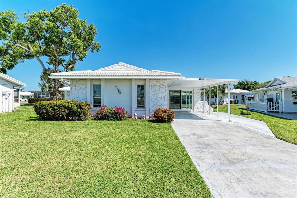 view of front of property featuring a front lawn and a carport