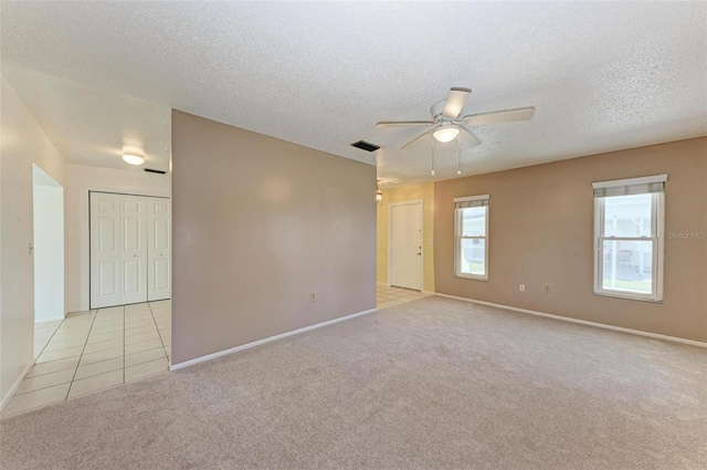 carpeted spare room with ceiling fan and a textured ceiling