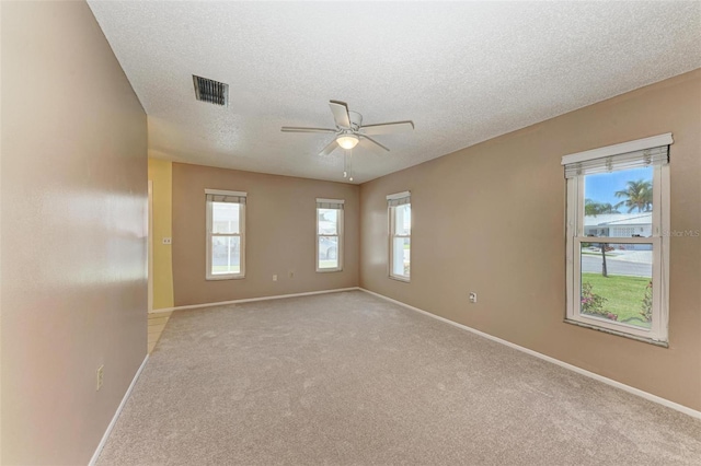 carpeted empty room with a textured ceiling and ceiling fan