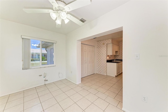 tiled spare room with sink and ceiling fan