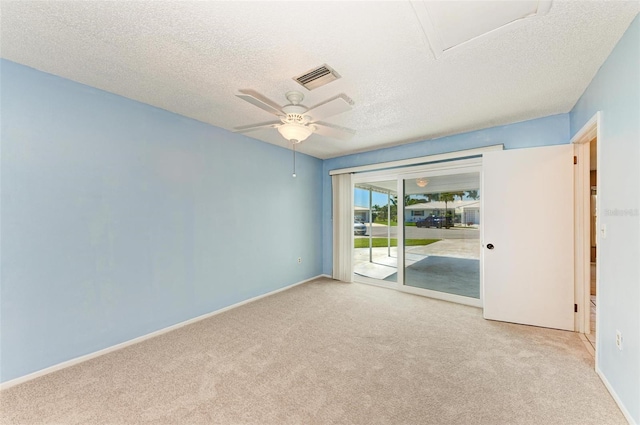 empty room featuring a textured ceiling, ceiling fan, and light carpet