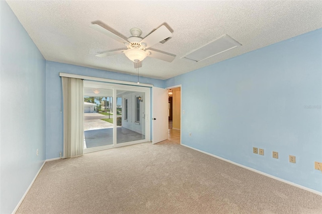 carpeted spare room featuring ceiling fan and a textured ceiling