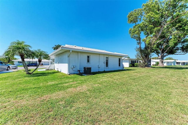 rear view of house with a yard and central air condition unit