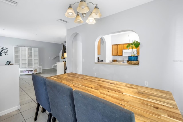 tiled dining area featuring a notable chandelier