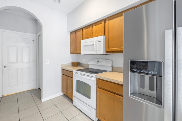 kitchen featuring white appliances and light tile flooring