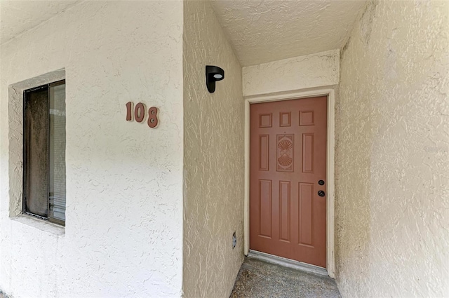 entrance to property featuring stucco siding