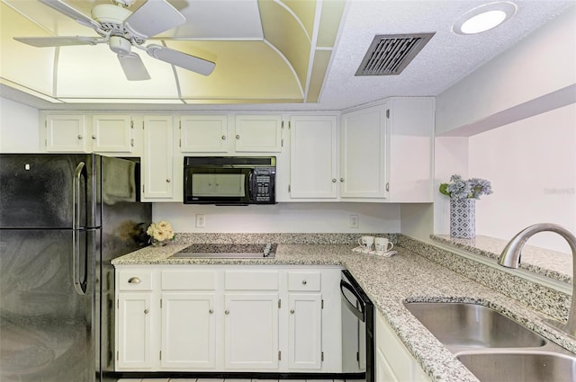 kitchen featuring white cabinetry, ceiling fan, black appliances, light stone counters, and sink