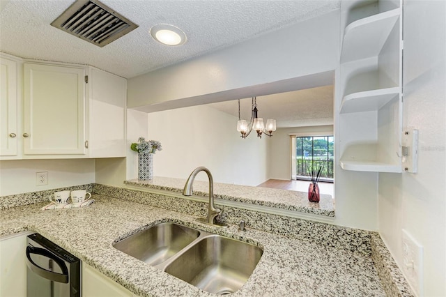 kitchen featuring light stone counters, sink, dishwashing machine, hardwood / wood-style flooring, and pendant lighting