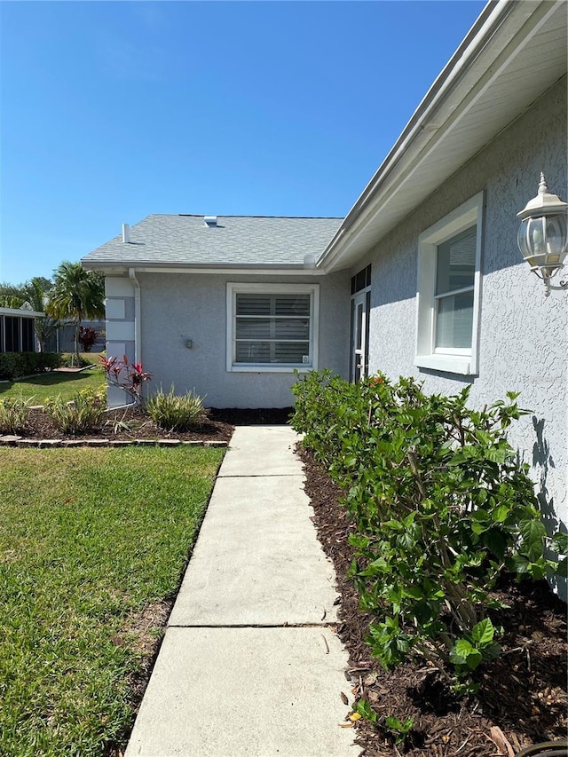 view of exterior entry featuring a yard