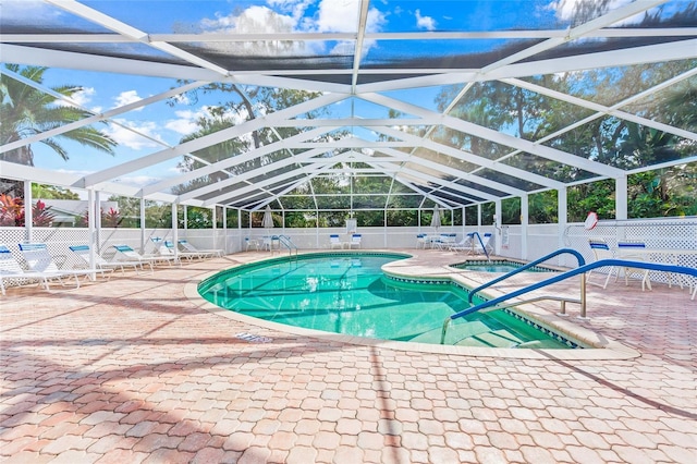 view of swimming pool with glass enclosure and a patio area