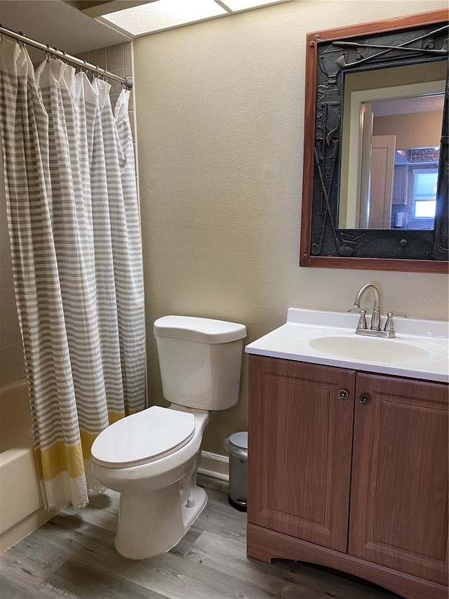 full bathroom with wood-type flooring, vanity, toilet, and shower / tub combo with curtain