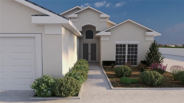 view of exterior entry featuring stucco siding, an attached garage, and french doors